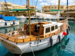 Classic wooden yacht moored at Puerto Marina Benalmádena with a teak deck and ship's wheel