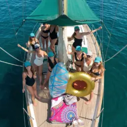 Aerial view of a group on a yacht's deck with a green awning and a golden float